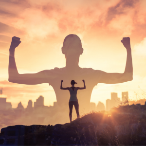 a silhouette of a woman standing on a mountain raising her arms in victory in front of a city sky line