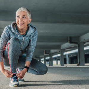 a woman kneeling down to tie her shoe