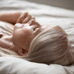 Woman sleeping upright on her bed