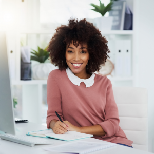 A woman happy and smiling while she works at her desk
