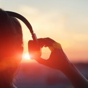 A woman putting on her headphones watching the sun rise