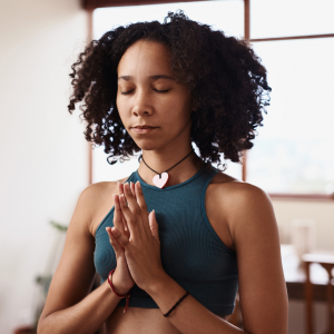 A woman in prayer hands pose meditating
