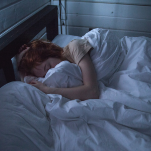 A woman deep sleeping buried in white blankets