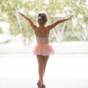 A little girl in a ballerina outfit dancing