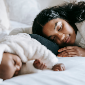 A woman sleeping next to her baby