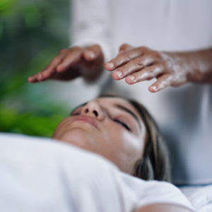 A woman laying down with her eyes closed and hands over her