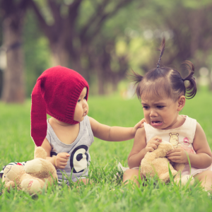 A baby comforting a crying baby in the park